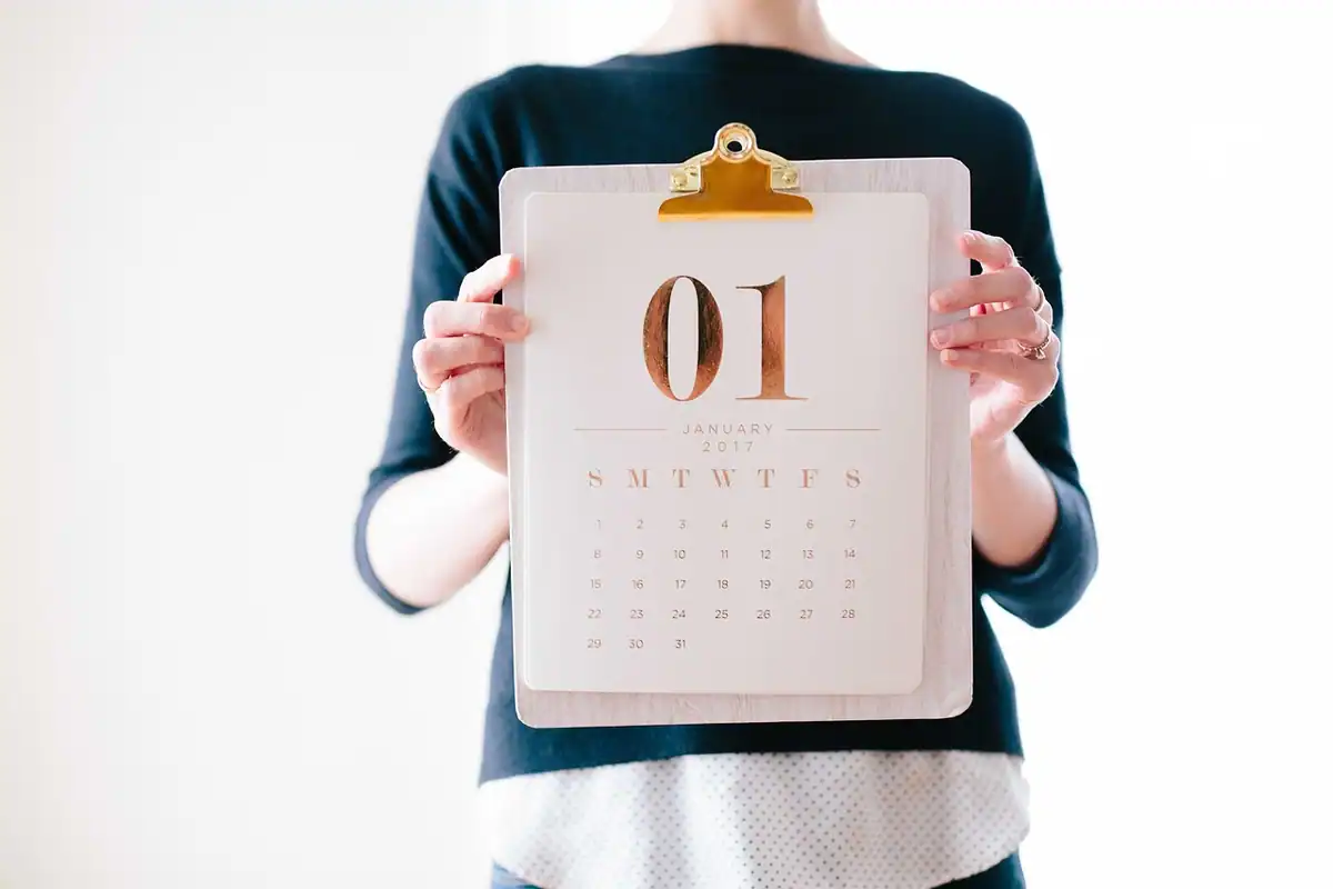 Mâini care țin un calendar de planificare deschis, pentru programarea unei analize hormonale