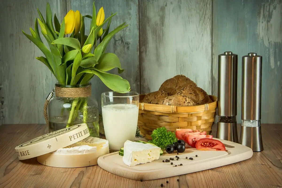 Pahar cu lapte și o scândură cu brânză, surse de calciu din alimentația de zi cu zi
