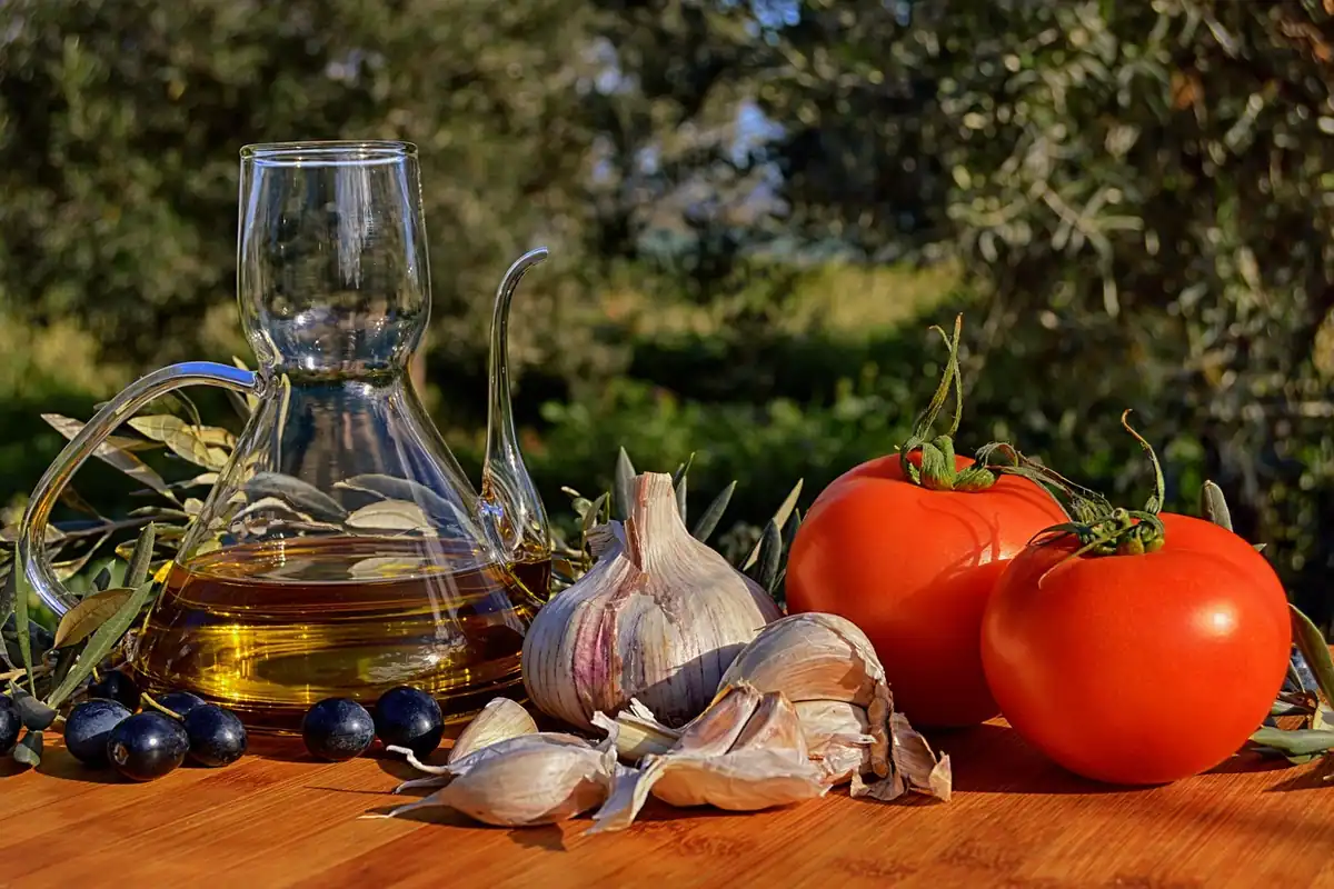 Legume proaspete și o sticlă de ulei de măsline pe o masă de bucătărie, alimentație echilibrată