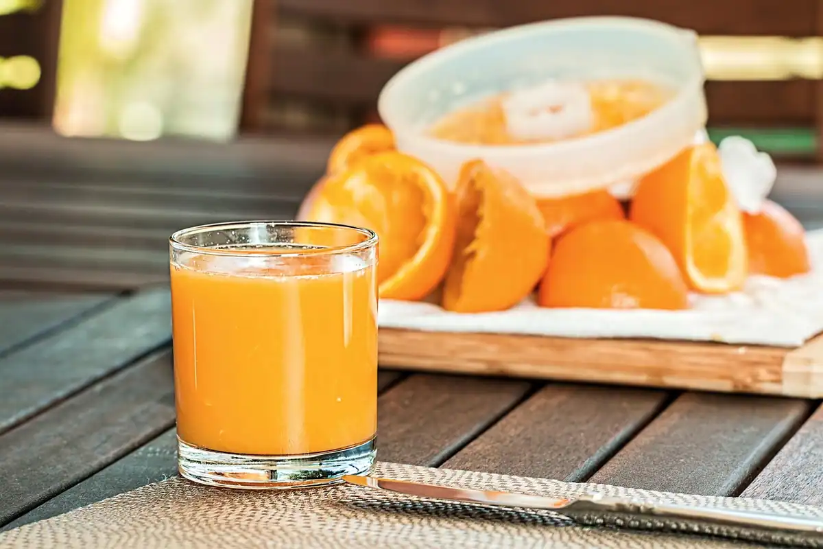 Vitamine prenatale și un pahar cu apă așezate pe o masă, pentru alimentația din sarcină