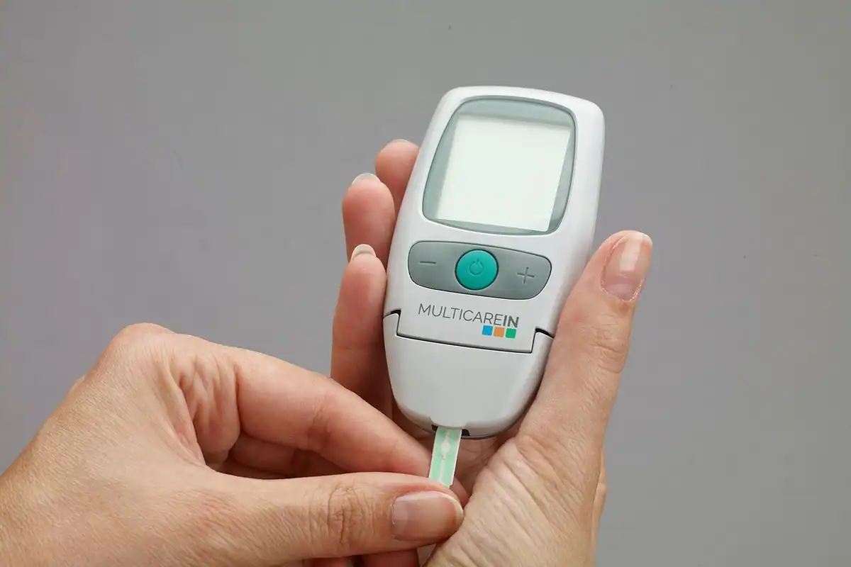 Glucometru și benzi de testare așezate pe o masă, pentru măsurarea glicemiei