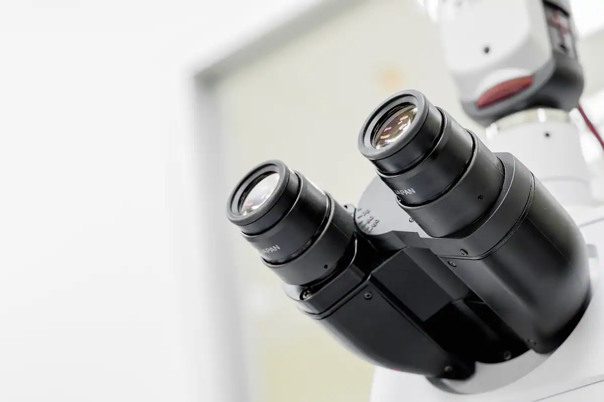 Microscop binocular alb pregătit pentru numărarea reticulocitelor pe frotiul de sânge