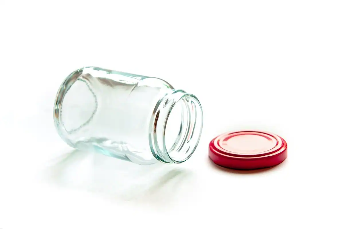 Recipient transparent din sticlă pentru probă de urină, așezat pe o suprafață curată